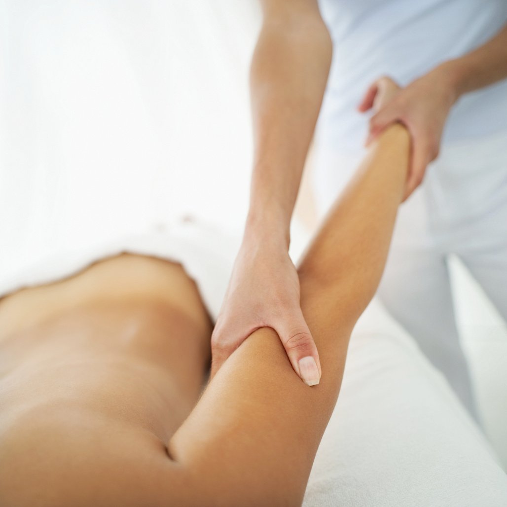 Young woman massaging other woman's arm